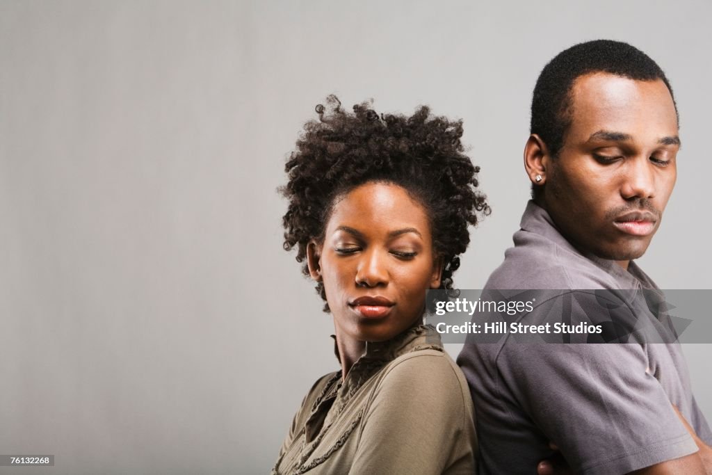 Angry African American couple standing back to back