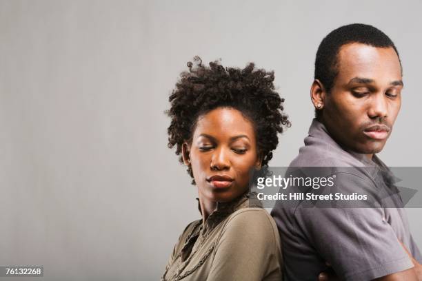 angry african american couple standing back to back - angry black woman stock pictures, royalty-free photos & images