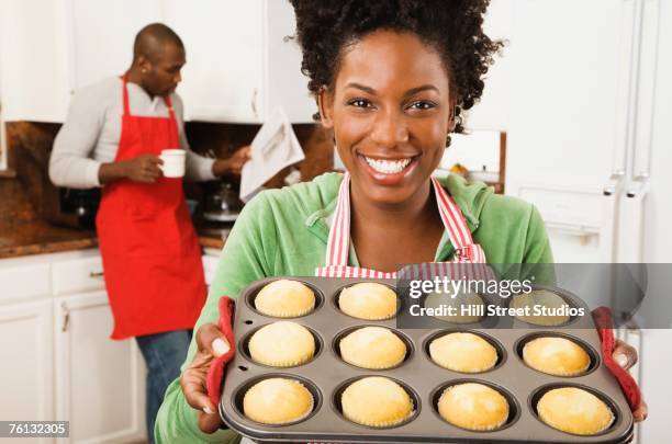 african american woman holding tray of muffins - baking pan stock pictures, royalty-free photos & images
