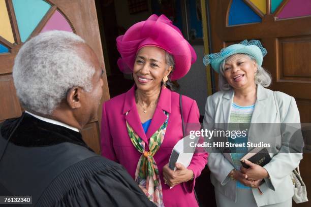 senior african american women talking to reverend - african american church stock pictures, royalty-free photos & images