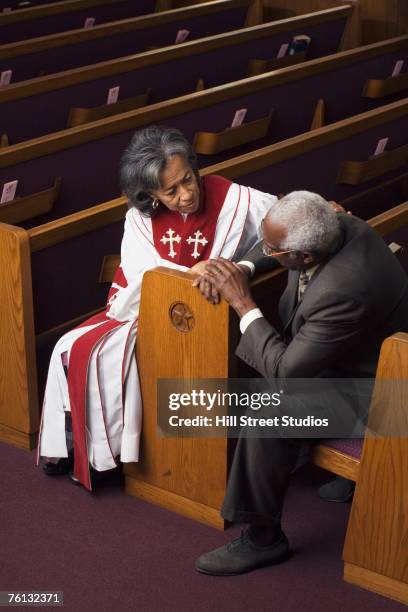 african american female reverend talking to parishioner - geestelijken stockfoto's en -beelden