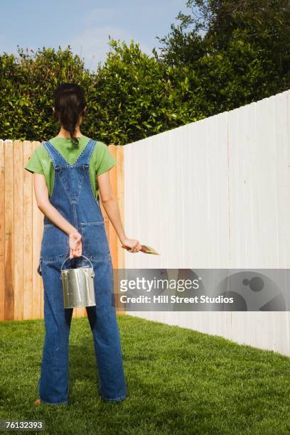 hispanic woman painting fence - looking over fence stock pictures, royalty-free photos & images