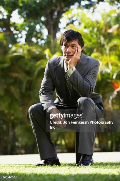 south american businessman sitting in park - boredom man fotografías e imágenes de stock