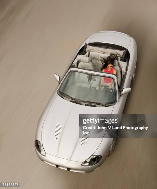 hispanic woman driving convertible car - sports car photos et images de collection