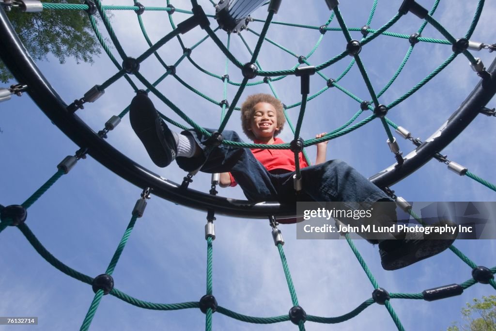 African American boy playing on jungle gym