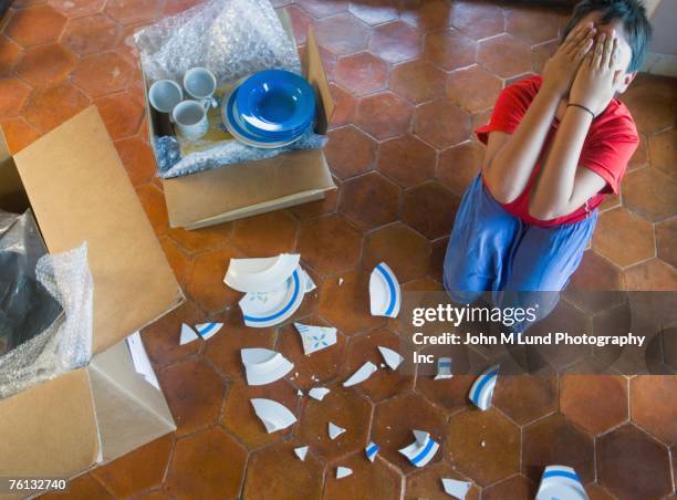 hispanic boy covering face next to broken plate - broken mug stock pictures, royalty-free photos & images