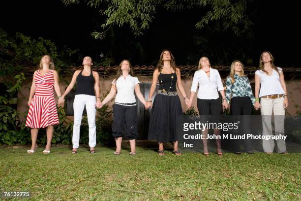 hispanic women holding hands in a row - new age stock pictures, royalty-free photos & images