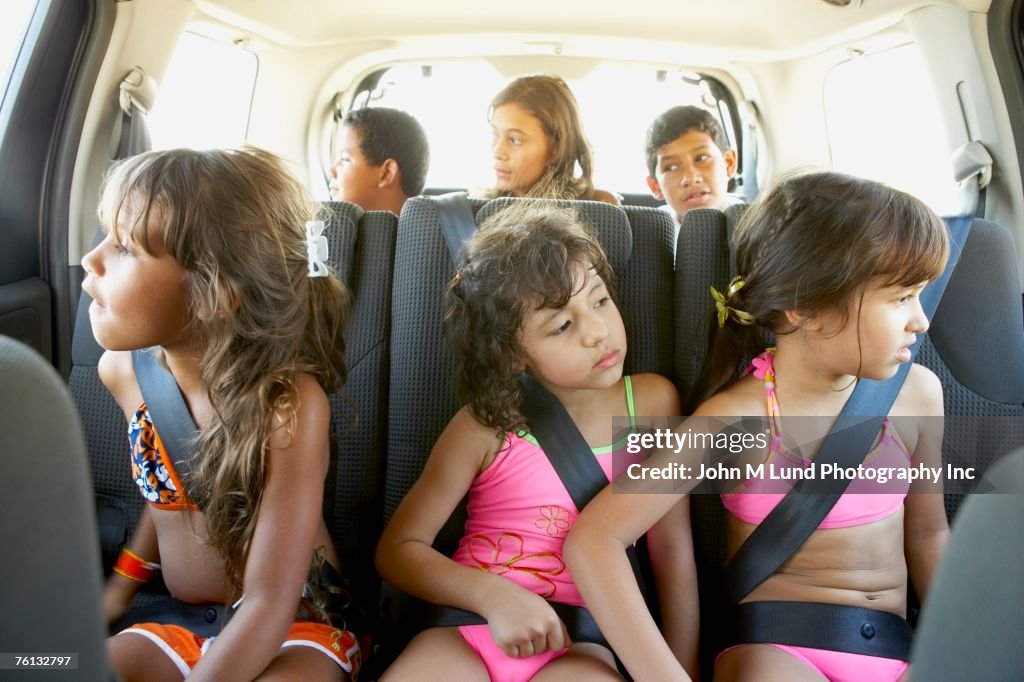 Hispanic children in car wearing seatbelts