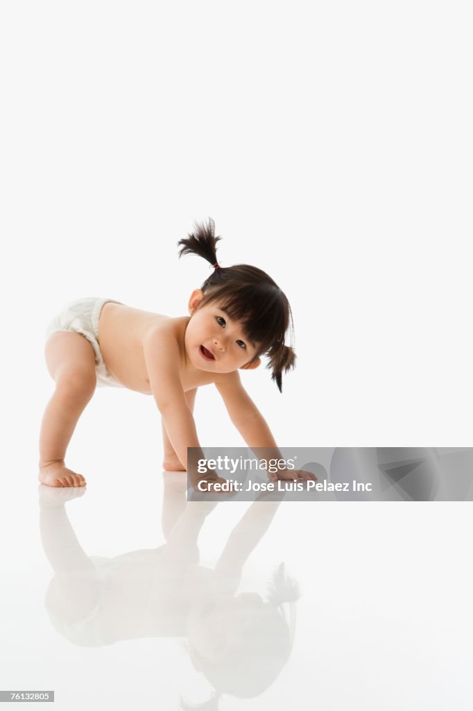 Studio shot of Asian baby crawling