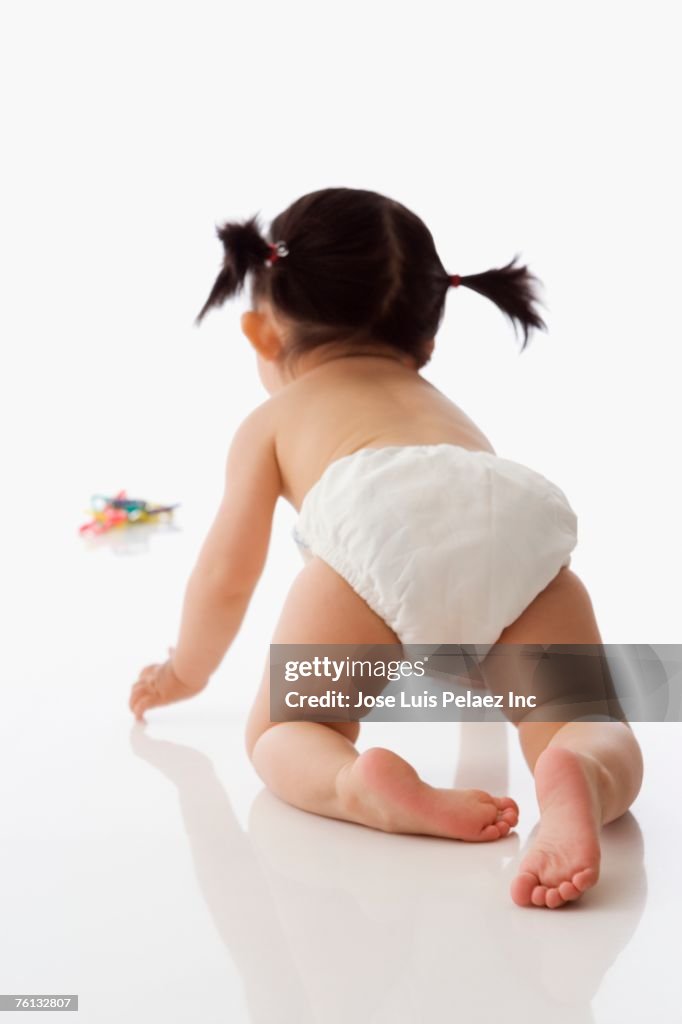 Studio shot of Asian baby crawling