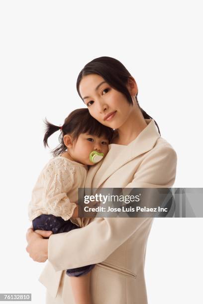 asian businesswoman hugging baby daughter - chinese family portrait isolated stock pictures, royalty-free photos & images