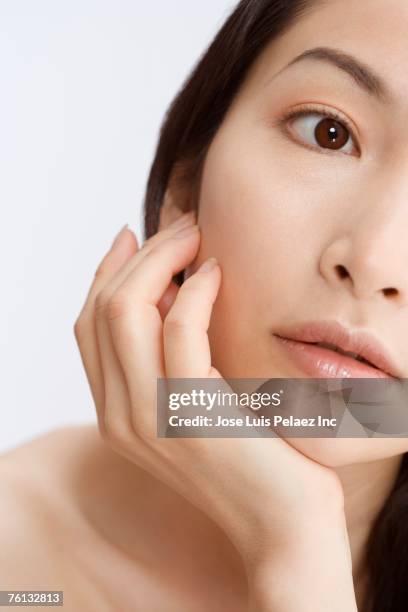 asian woman leaning chin on hand - hand on chin stock-fotos und bilder