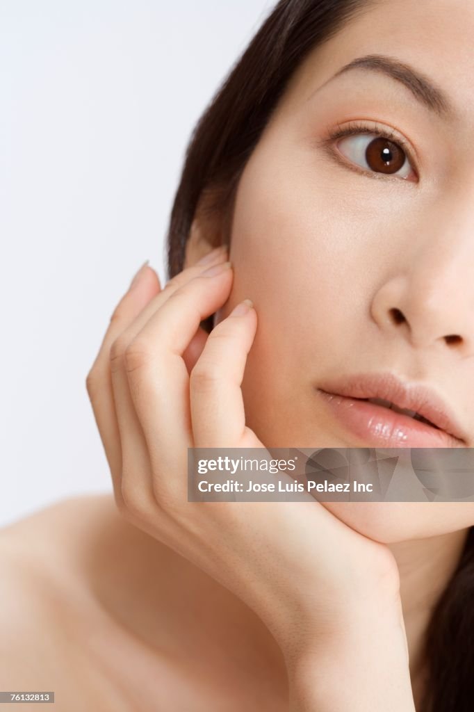 Asian woman leaning chin on hand