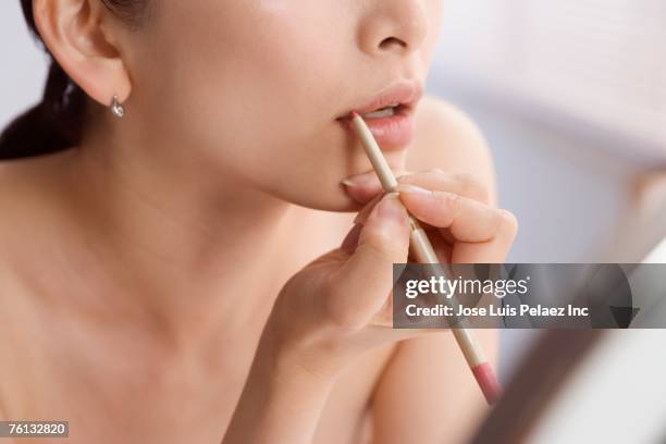 asian woman applying lip liner - human lips stock pictures, royalty-free photos & images