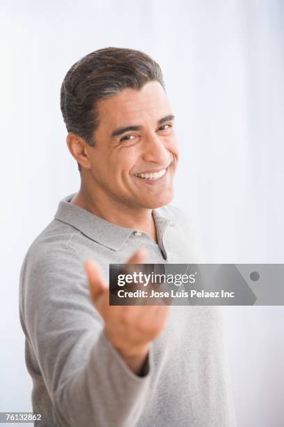 hispanic man beckoning with hand - heranlocken stock-fotos und bilder