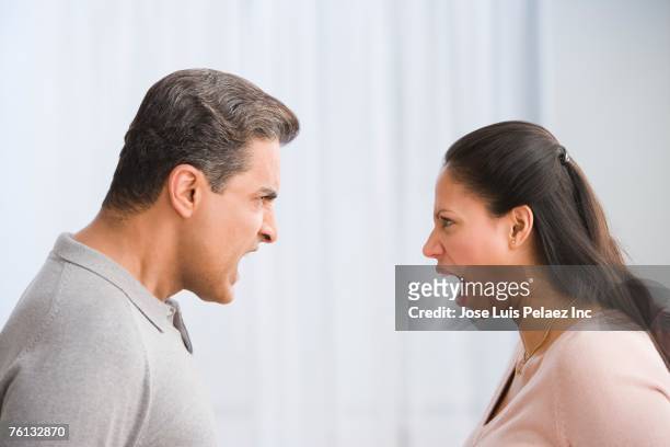 hispanic couple yelling at each other - diverbio foto e immagini stock