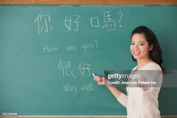 asian female teacher writing chinese on blackboard - teacher pointing finger stock pictures, royalty-free photos & images