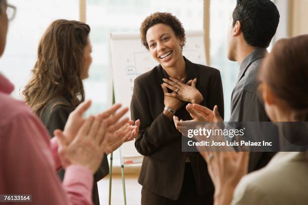 multi-ethnic businesspeople clapping for coworker - gratitude foto e immagini stock