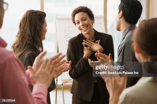 multi-ethnic businesspeople clapping for coworker - tímido imagens e fotografias de stock