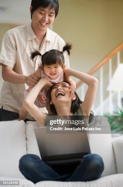 asian family playing on sofa - mom flirting stockfoto's en -beelden
