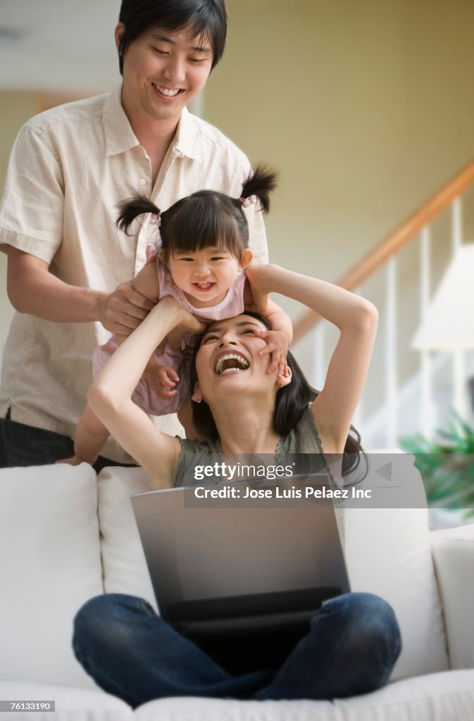 Asian family playing on sofa