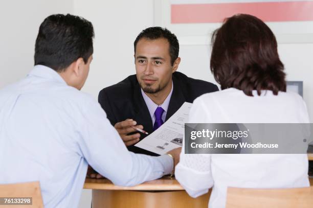 hispanic couple making deal with car salesman - unhappy salesman stock pictures, royalty-free photos & images