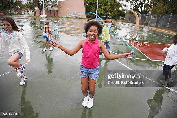 multi-ethnic children playing in urban area - 縄跳びをする ストックフォトと画像