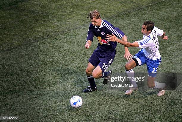 Davy Arnaud of the Kansas City Wizards and Dave van den Bergh of the New York Red Bulls battle for the ball at Giants Stadium in the Meadowlands on...