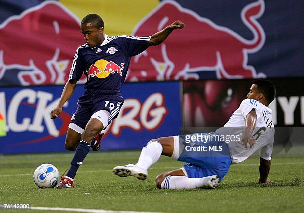 Dane Richards of the New York Red Bulls crosses the ball past Davy Arnaud of the Kansas City Wizards at Giants Stadium in the Meadowlands on June 16,...