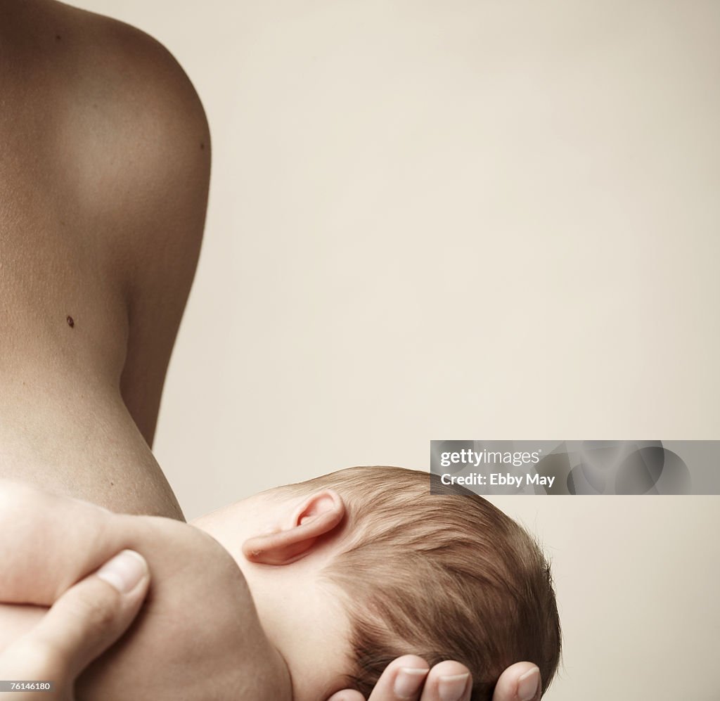 Mother breastfeeding baby girl (0-3 months), close-up