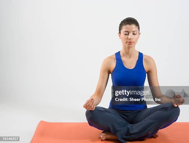 young woman doing yoga, studio shot - yoga studio shot stock pictures, royalty-free photos & images