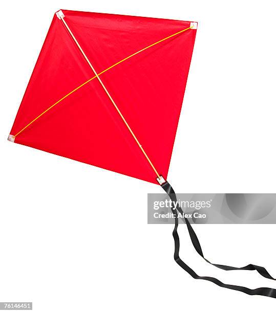red kite with black ribbon tail - kite toy stock-fotos und bilder
