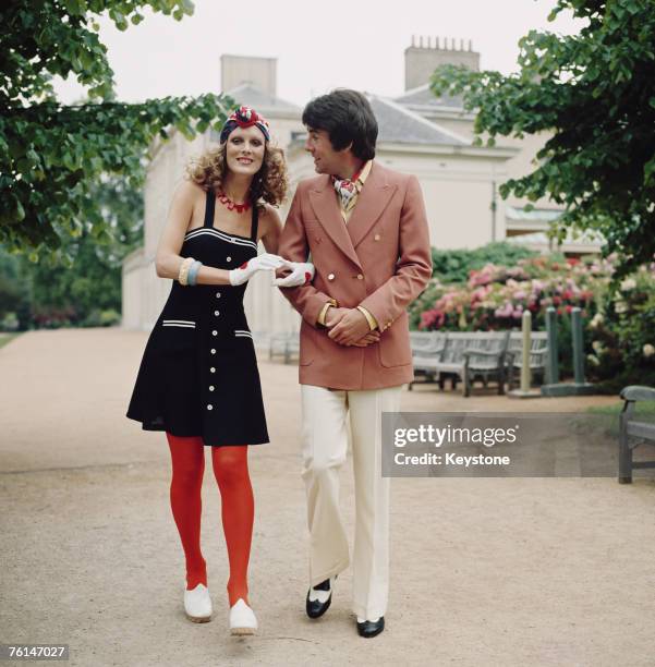 Models wearing 1920's retro-styled oufits, circa 1972. The man wears a peach-coloured double-breasted blazer with cravat and two-tone shoes. The...