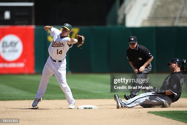 Paul Konerko of the Chicago White Sox slides safely into second base as Oakland Athletics second baseman Mark Ellis fields the throw from the...