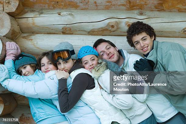 "young friends standing by log cabin, leaning on each other, portrait" - northern european descent stockfoto's en -beelden