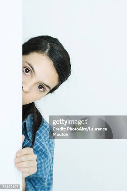 "teen girl peeking around wall, looking at camera" - looking around on white background stock pictures, royalty-free photos & images