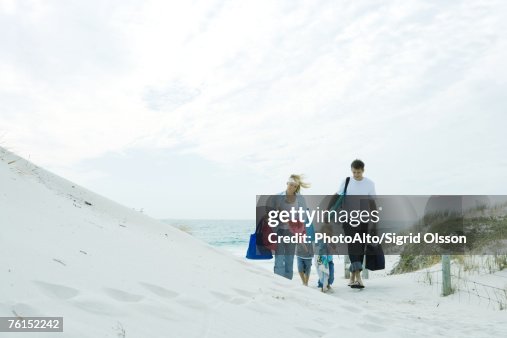 Family walking through dunes to beach Family walking through dunes to beach