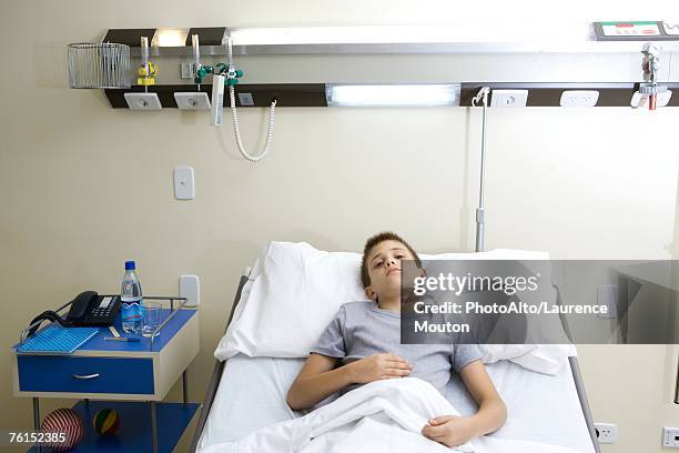 "boy lying in hospital bed, holding stomach" - child in hospital bed stock pictures, royalty-free photos & images