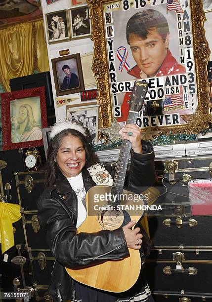 Toni Silva of Houston, Texas poses with leather jacket and guitar at "Graceland Too", a vast collection of Elvis Presley related items by fan Paul...