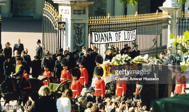 The coffin of Diana, Princess of Wales passes a poster 'DIANA OF LOVE' as it leaves Buckingham Palace for her funeral at Westminster Abbey on...