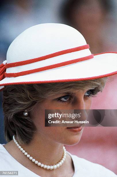 Diana, Princess of Wales, wearing a red dress with a white collar designed by Jan Van Velden and a hat by John Boyd, visits Alberta Legislature...