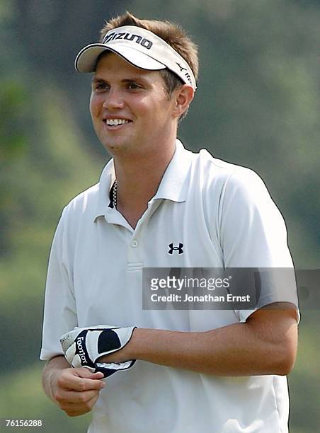 Jeff Overton smiles as he walks up the ninth fairway during the second round of the Wyndham Championship at Forest Oaks Country Club on August 17,...