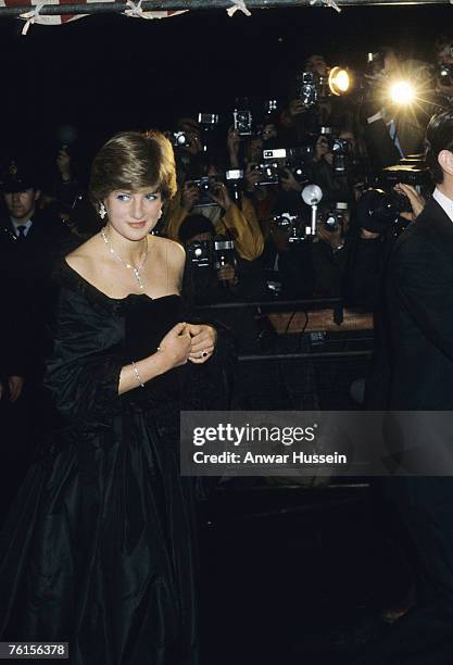 Lady Diana Spencer, wearing a strapless black taffeta dress designed by David and Elizabeth Emanuel, attend a fundraising concert and reception at...