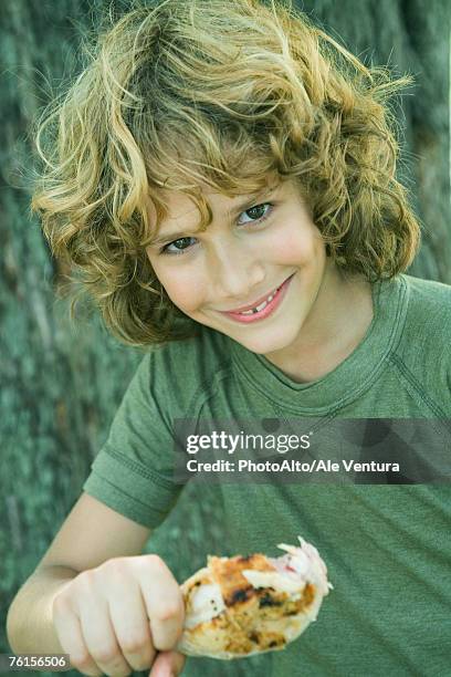 "boy holding grilled chicken leg, smiling at camera, portrait" - legale stockfoto's en -beelden