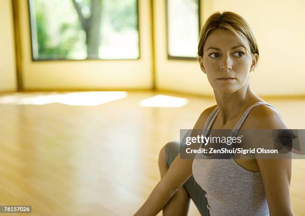 woman sitting in exercise studio, looking away - spinal twist stock pictures, royalty-free photos & images