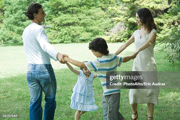 family outdoors playing ring-around-the-rosy - ring around the rosy stock pictures, royalty-free photos & images