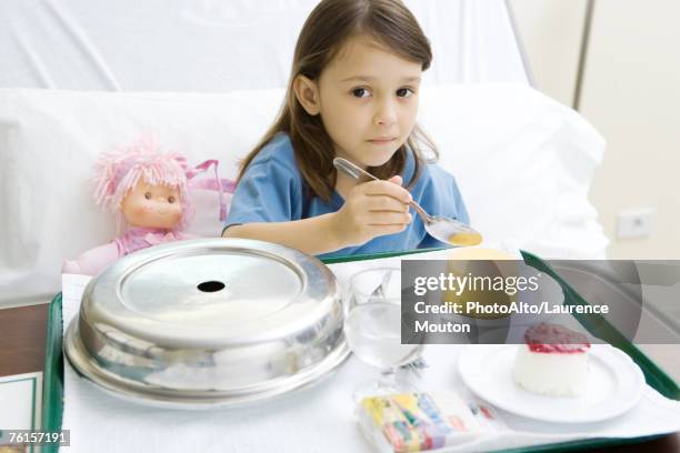 girl eating meal in hospital bed - spoon in bed stock pictures, royalty-free photos & images