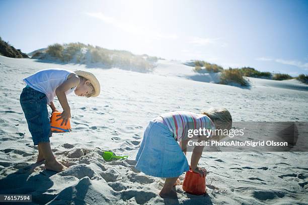 children playing in sand - bending over in skirt stock-fotos und bilder