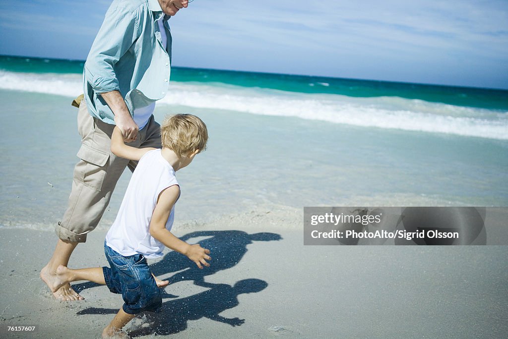 Man and boy walking on beach
