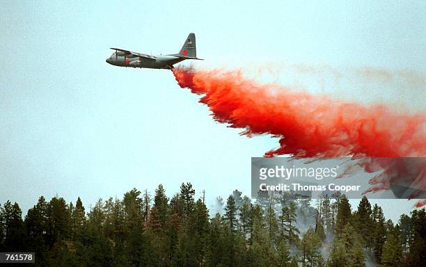 Slurry bomber drops its load on top of a ridge in an effort to stop the Hayman fire that is south west of Denver June 14, 2002 in Deckers, Colorado....